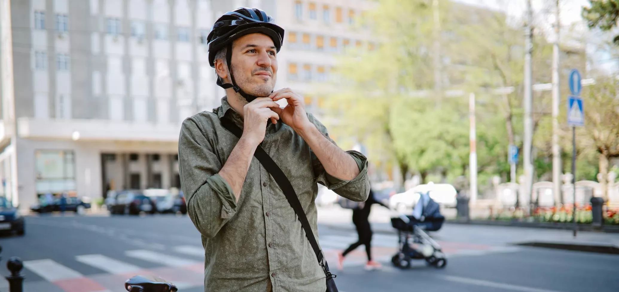 Een man naast een fiets zet een helm op